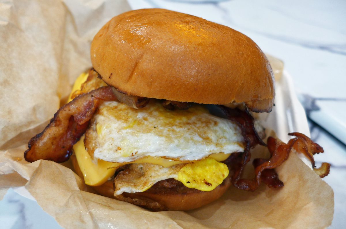 A piled-high egg sandwich with all sorts of crap in it.