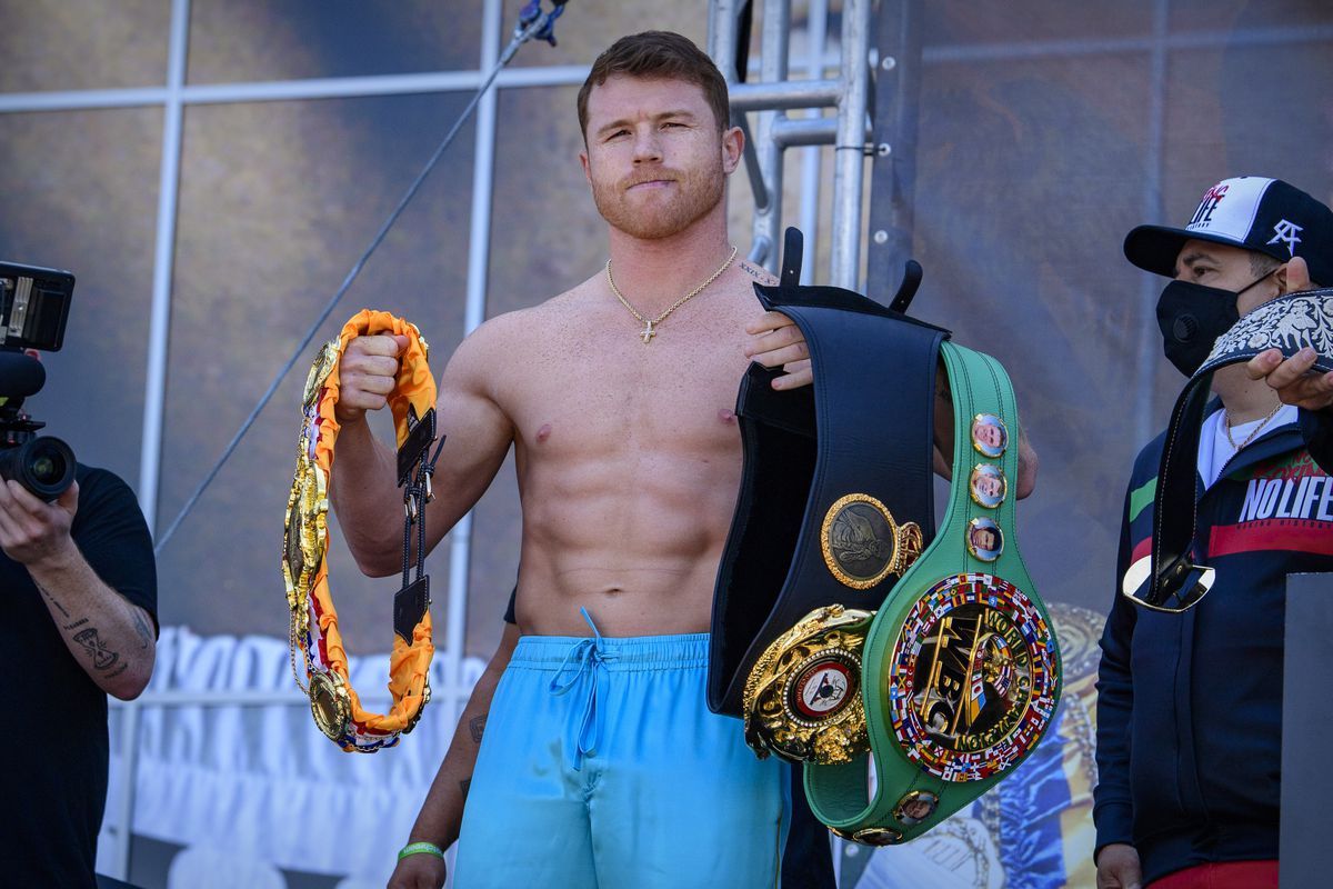Boxer Canelo Alvarez poses for the fans with his title belts during weigh ins for his super middleweight boxing title fight against Billy Joe Saunders at AT&amp;T Stadium.