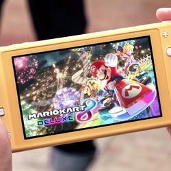 Mario Kart 8 Deluxe is shown running on a yellow handheld-only Nintendo Switch Lite.