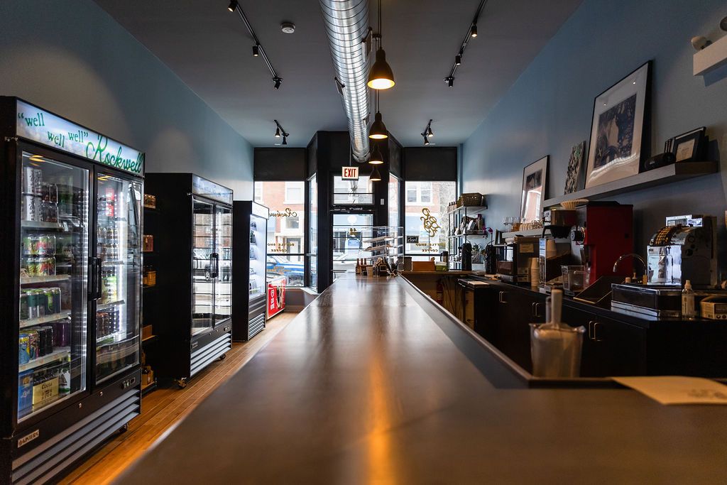 A long, narrow alcohol retail space with a long wooden counter.