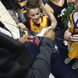 Utah Jazz guard Donovan Mitchell (45) signs a shoe for a fan after beating the Minnesota Timberwolves 120 to 100 at Vivint Smart Home Arena in Salt Lake City on Thursday, March 14, 2019.