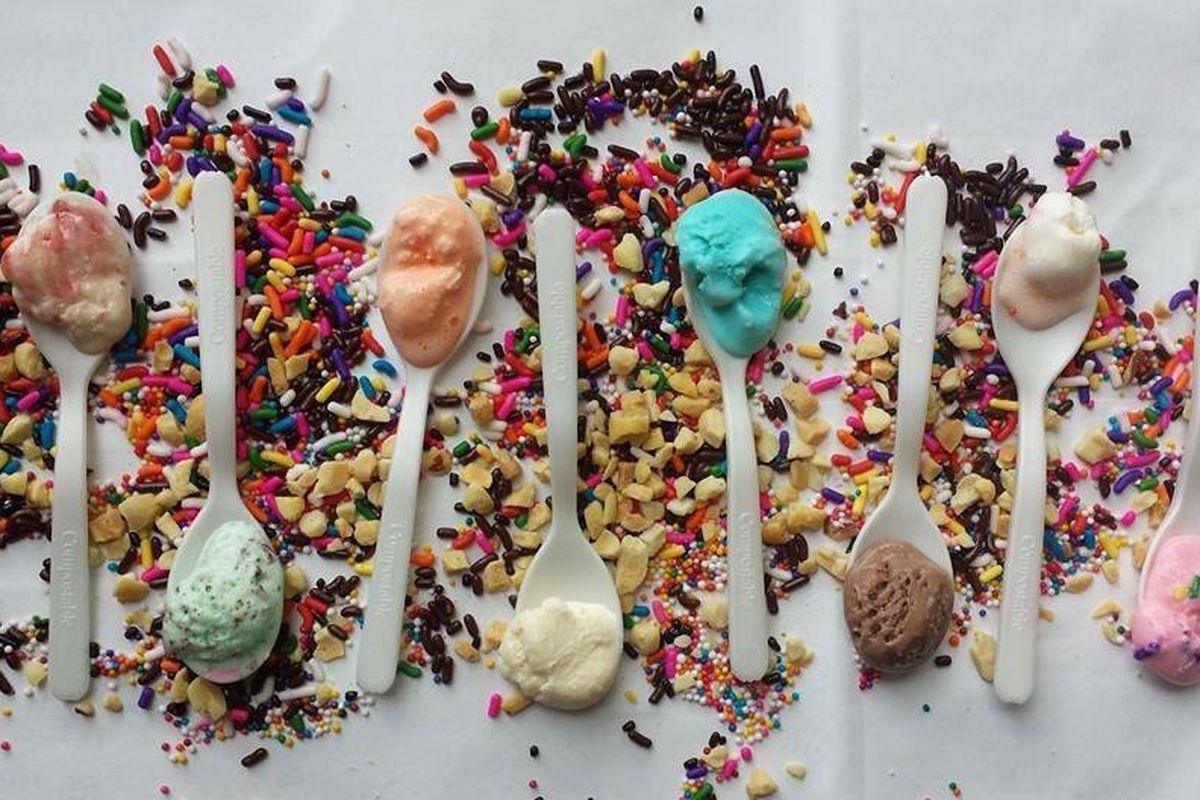 A top-down view of a plastic spoons holding a variety of ice cream flavors.