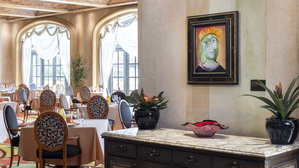 A cubist painting hangs over a sideboard in a restaurant