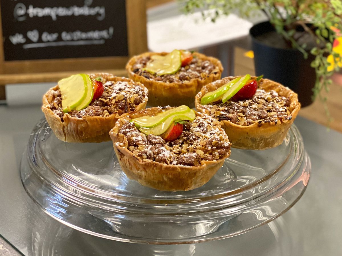 Four fruit-topped tartlets on a plate