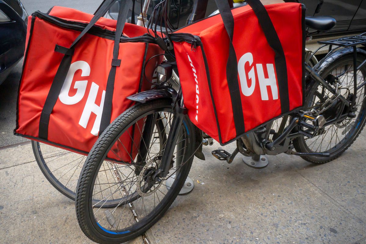 A bike with two red Grubhub bags hanging from it