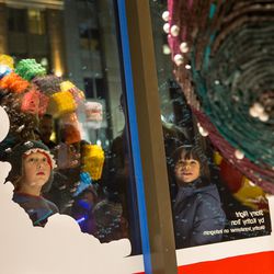 Children peer through the windows at candy ornaments during an unveiling celebration for the Macy's holiday candy windows at the City Creek Center in Salt Lake City on Thursday, Nov. 17, 2016.