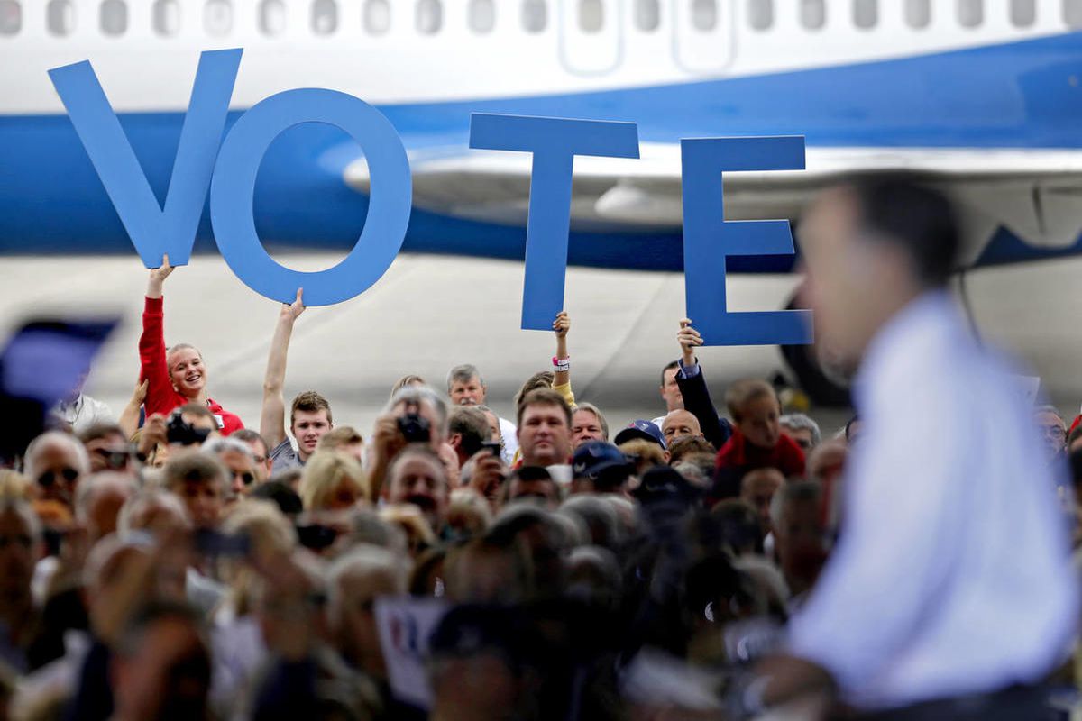 Crowd members hold up a sign reading "vote" as Republican presidential candidate, former Massachusetts Gov. Mitt Romney speaks during a campaign event at the Orlando Sanford International Airport, Monday, Nov. 5, 2012, in Sanford, Fla. 