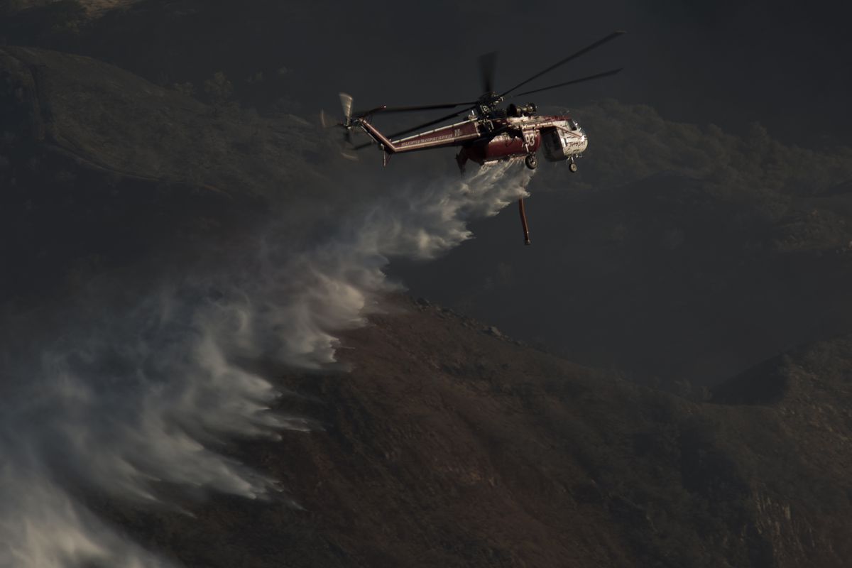 A Sikorsky S-64 drops water on a California wildfire.