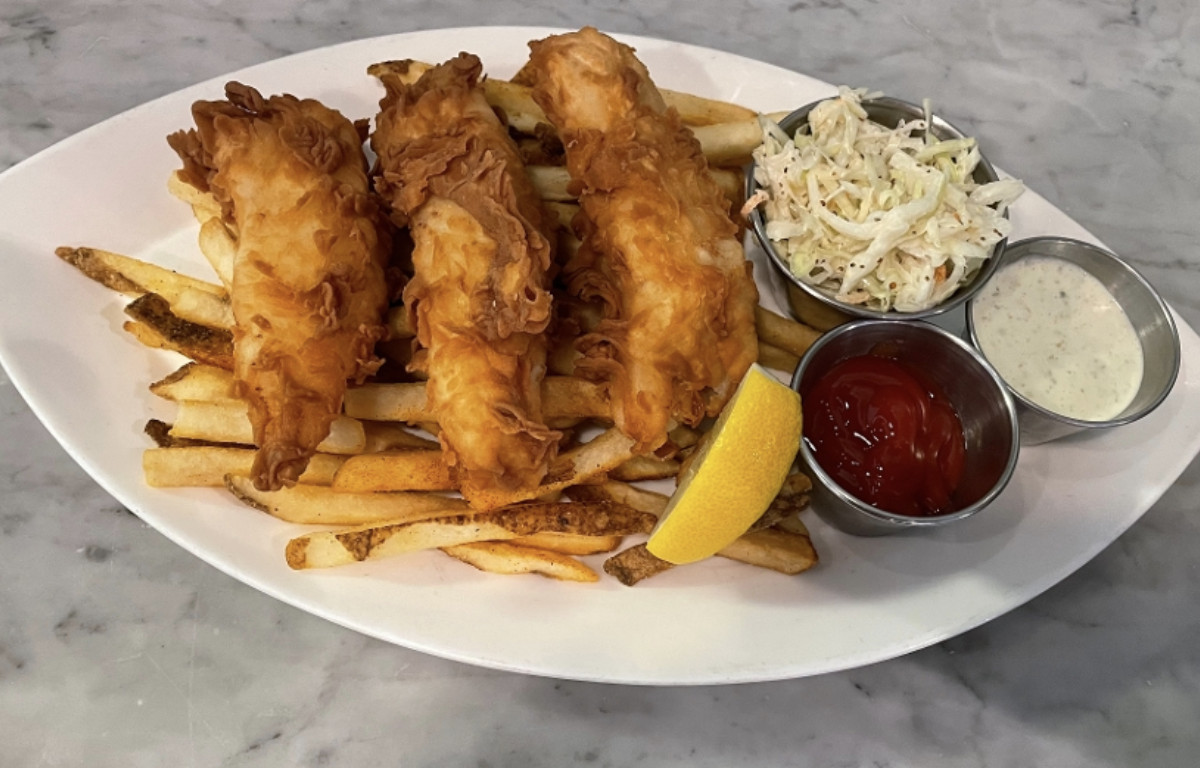 Fried fish and chips with slaw on a white plate
