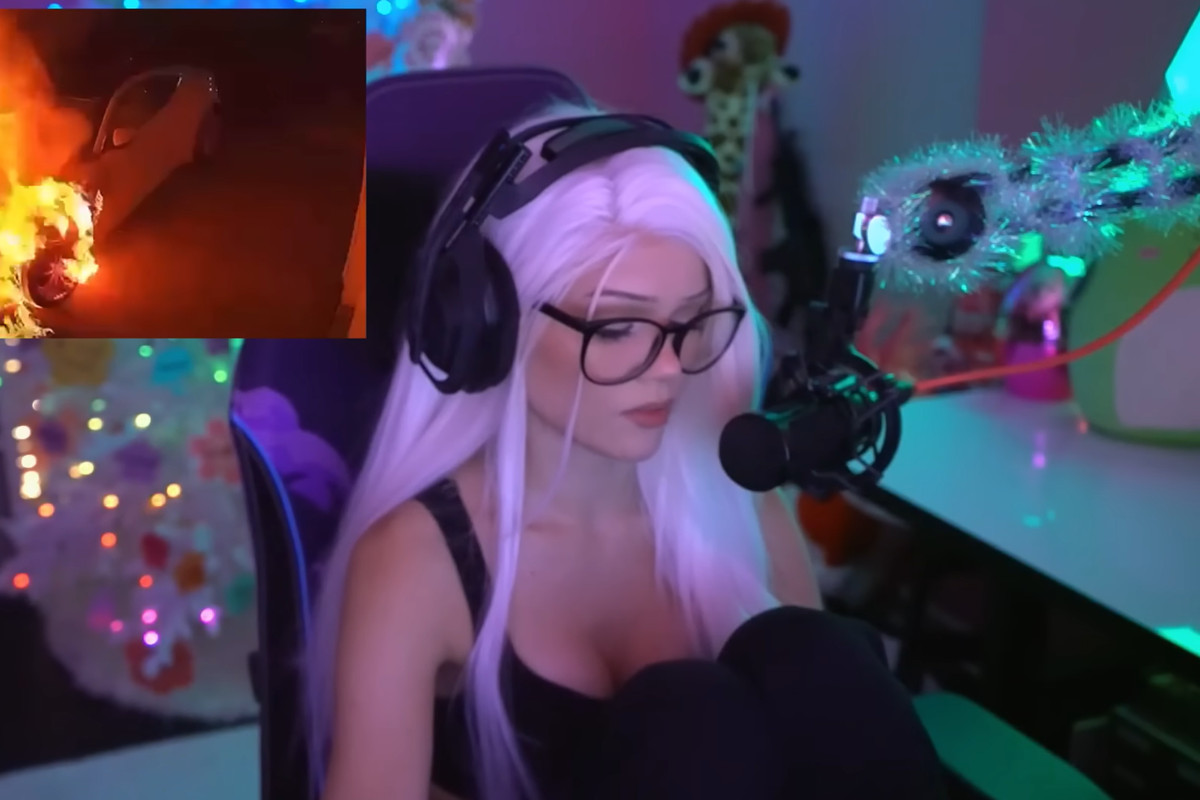 Twitch streamer Kylee Carter, known as justfoxii online, sits in front of the camera. There’s a photo in the left-hand top corner of a car that’s on fire.