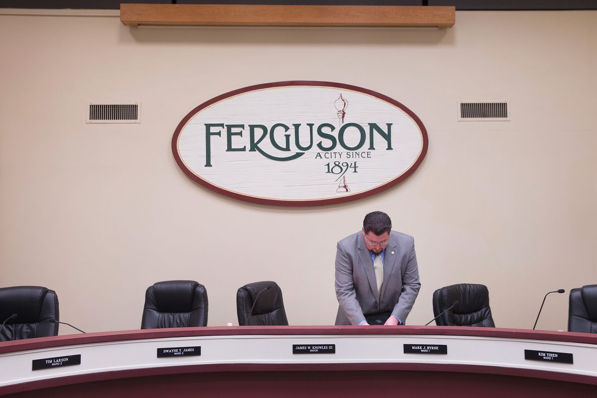 Ferguson Mayor James Knowles packs up following a city council meeting.