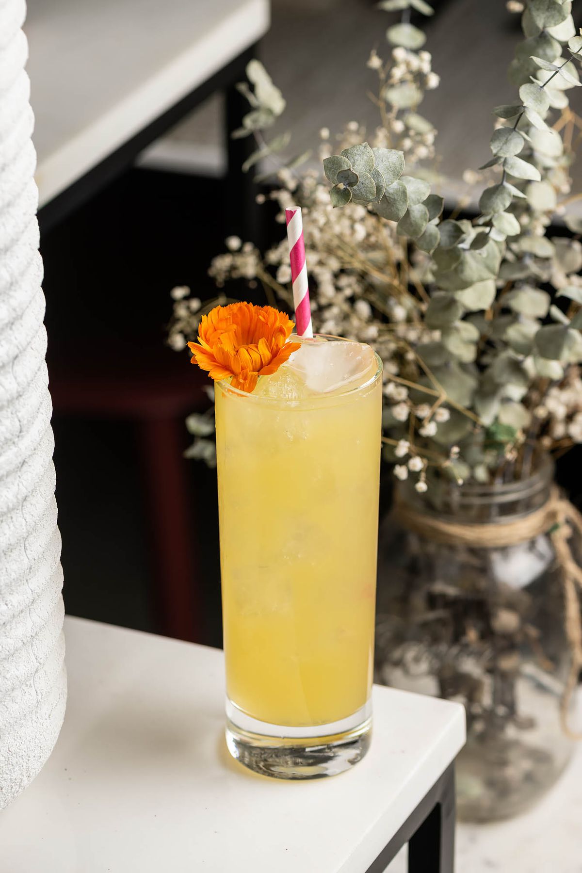 Yellow cocktail with orange flower at Flor y Solera.