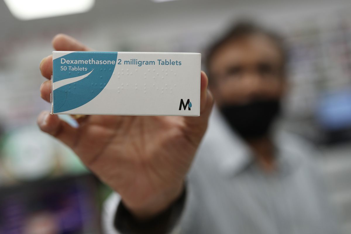 A pharmacist in London holds a packet of the anti-inflammatory drug dexamethasone.