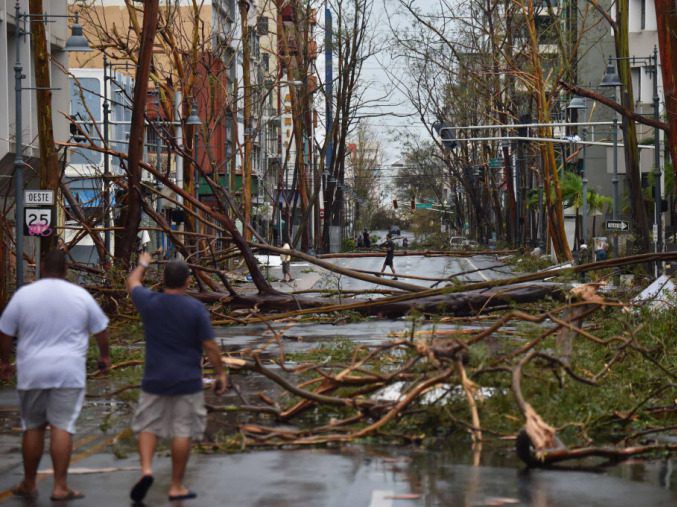 Men walk damaged trees after the passage of Hurricane Maria, in San Juan, Puerto Rico, on September 20, 2017. | Getty Images file photo