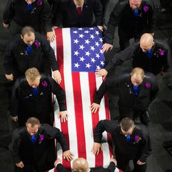Pallbearers walk with the casket and body of West Valley City Police officer Cody Brotherson as they enter for funeral services at the Maverik Center in West Valley City on Monday, Nov. 14, 2016.
