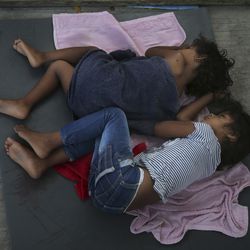 Migrant children sleep on a mattress on the floor of the AMAR migrant shelter in Nuevo Laredo, Mexico, Wednesday, July 17, 2019. Asylum-seekers grappled to understand what a new U.S. policy that all but eliminates refugee claims by Central Americans and many others meant for their bids to find a better life in America amid a chaos of rumors, confusion and fear. (AP Photo/Marco Ugarte)