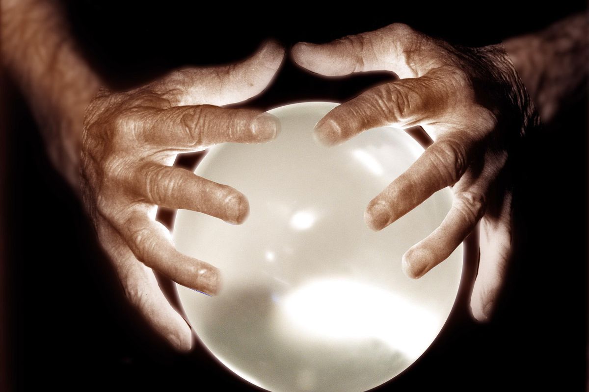 Photo-illustration shows a crystal ball with two hands. Financial planners unsur