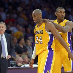 Los Angeles Lakers guard Kobe Bryant, center, is consoled by forward Metta World Peace, right, as head coach Mike D'Antoni looks on after being injured during the second half of their NBA basketball game against the Golden State Warriors, Friday, April 12, 2013, in Los Angeles. The Lakers won 118-116. (AP Photo/Mark J. Terrill)