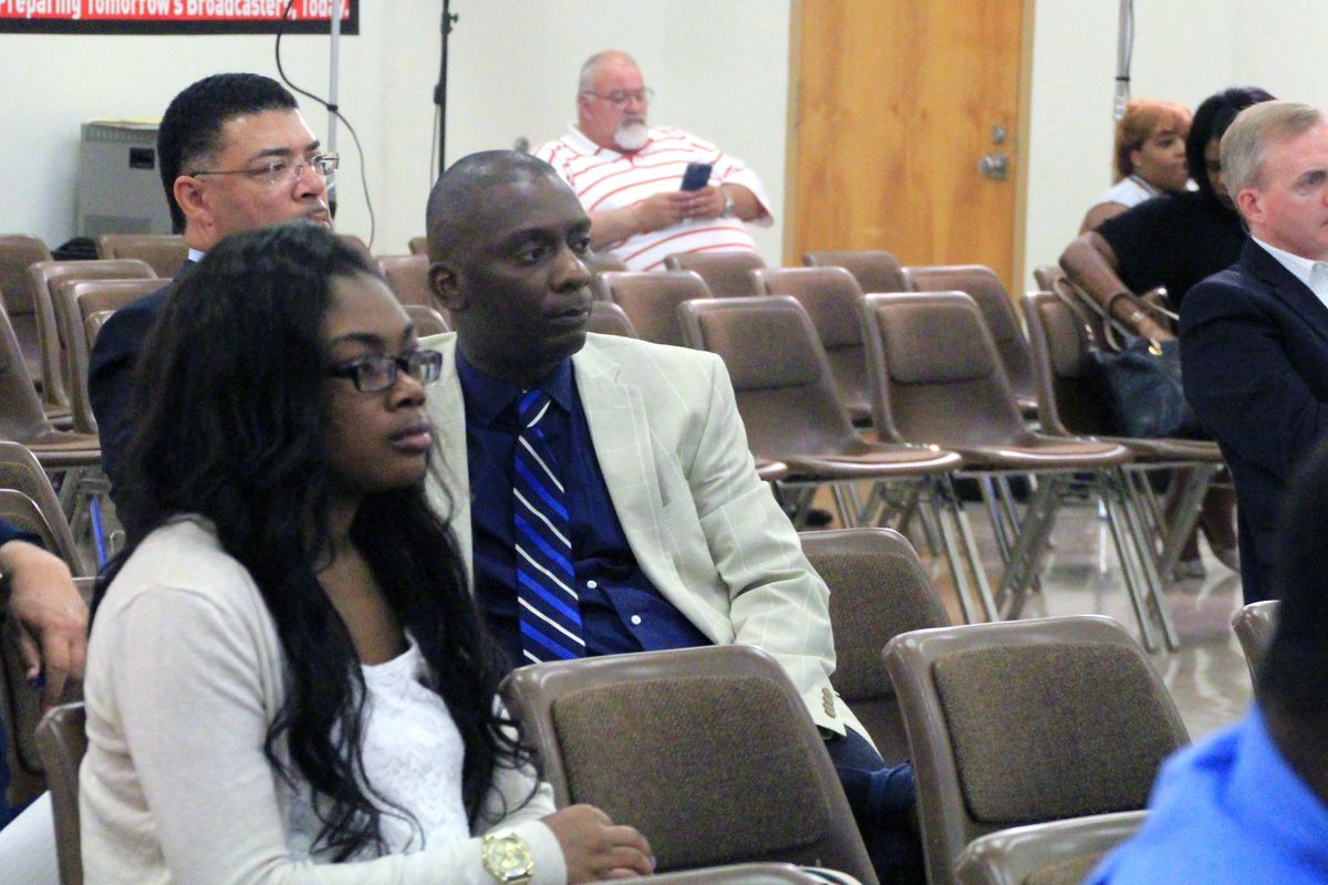 Tommie Henderson, executive director of the New Consortium of Law and Business, listens as district school board members discuss the future of the school.