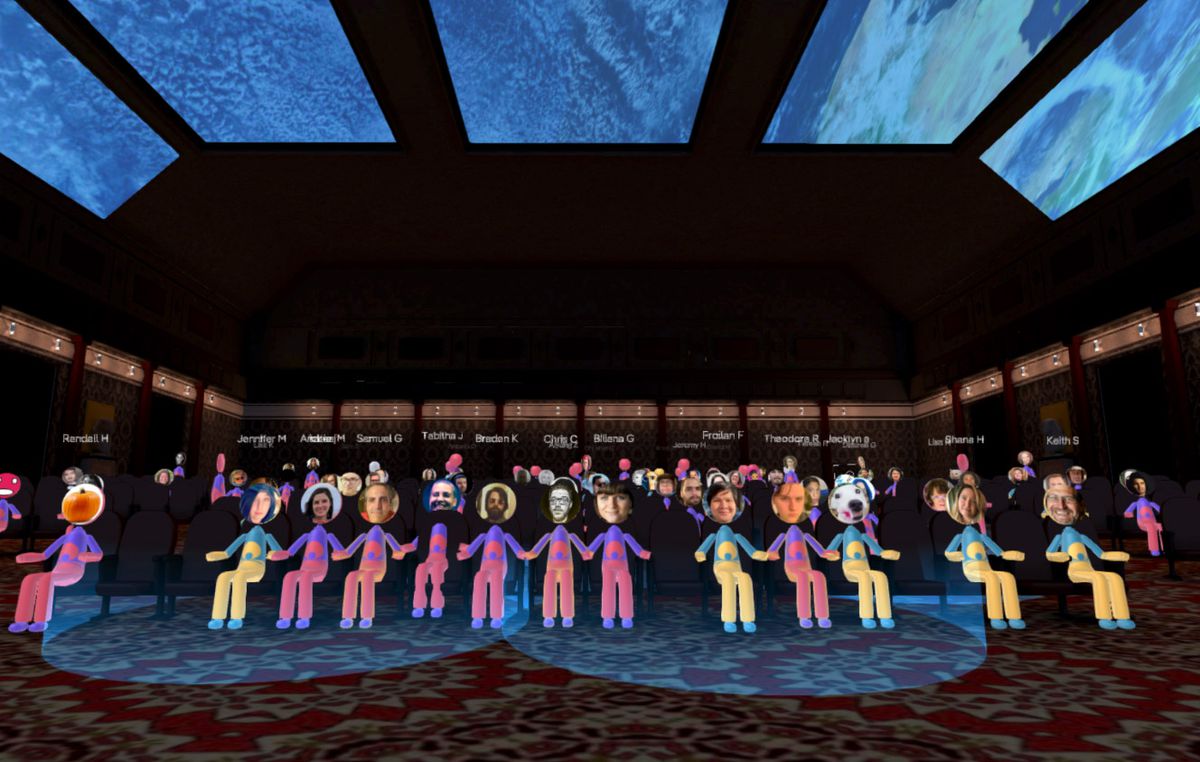 A room full of cartoonish avatars sit in a theater-style space.