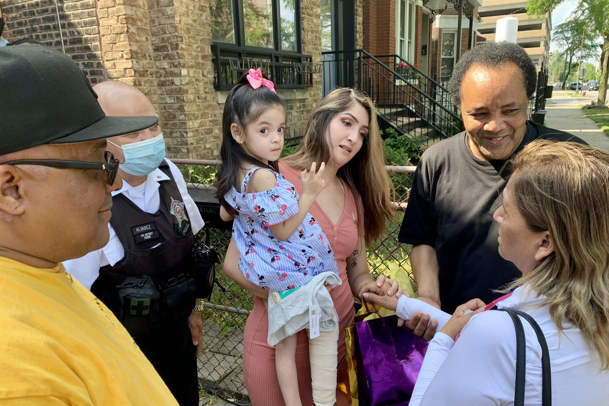 Angelina Rodriguez is held by her mother Perla Rodriguez Saturday outside their West Side home.