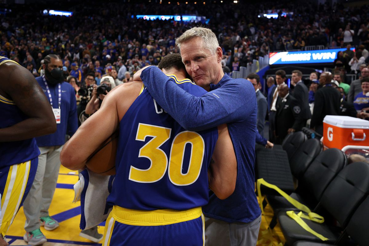 Steve Kerr hugging Steph Curry. 