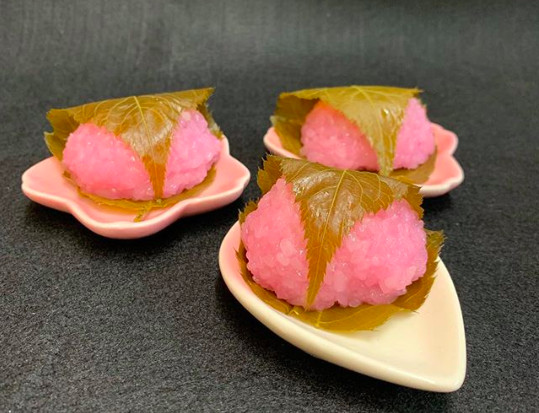 Seasonal sakura mochi, sweet rice filled with red bean paste and delicately wrapped in a cherry blossom leaf.
