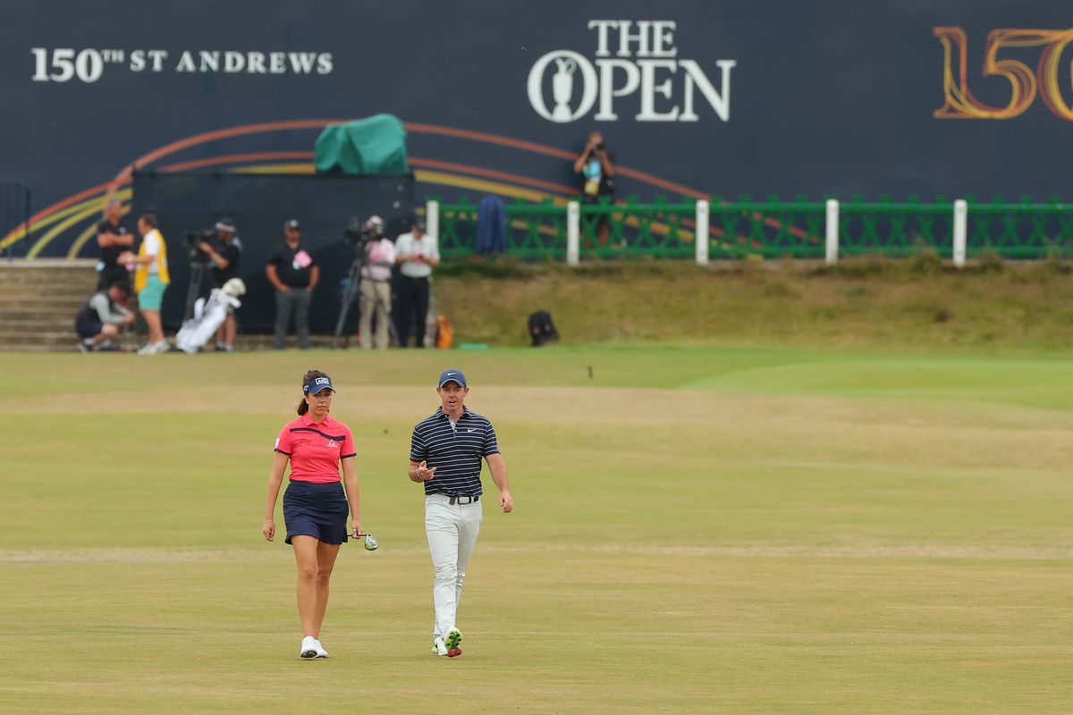 Rory McIlroy of Northern Ireland and Georgia Hall of England walk down the 1st during the Celebration of Champions Challenge during a practice round prior to The 150th Open at St Andrews Old Course on July 11, 2022 in St Andrews, Scotland.