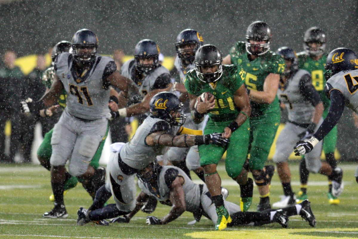 Thomas Tyner breaks through the Cal defense during a torrential downpour in Autzen Stadium
