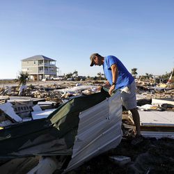 Mike Jackson sifts through debris looking for remnants of his home which was destroyed by hurricane Michael in Mexico Beach, Fla., Saturday, Oct. 13, 2018. (AP Photo/David Goldman)