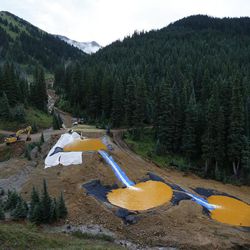 FILE - In this Aug. 12, 2015 file photo, water flows through a series of retention ponds built to contain and filter out heavy metals and chemicals from the Gold King mine chemical accident, in the spillway about 1/4 mile downstream from the mine, outside Silverton, Colo. A temporary treatment plant, not pictured, has begun cleaning up polluted water flowing from the Gold King Mine in southwestern Colorado after an accident sent millions of gallons of waste into rivers in three states. The Environmental Protection Agency said Monday, Oct. 19, 2015 that the $1.8 million plant is processing up to 800 gallons per minute, including water flowing from the mine and water stored in ponds. 
