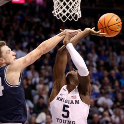 Utah State Aggies forward Justin Bean (34) fouls Brigham Young Cougars forward Gideon George (5) as BYU and Utah State play an NCAA basketball game in Provo at the Marriott Center on Wednesday, Dec. 8, 2021. BYU won 82-71.