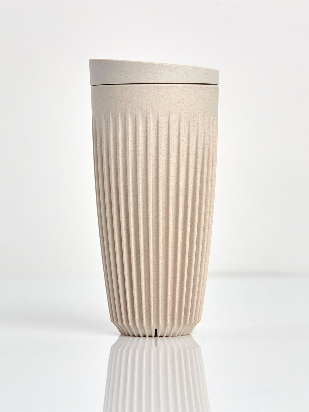 A beige cup with a ridged design