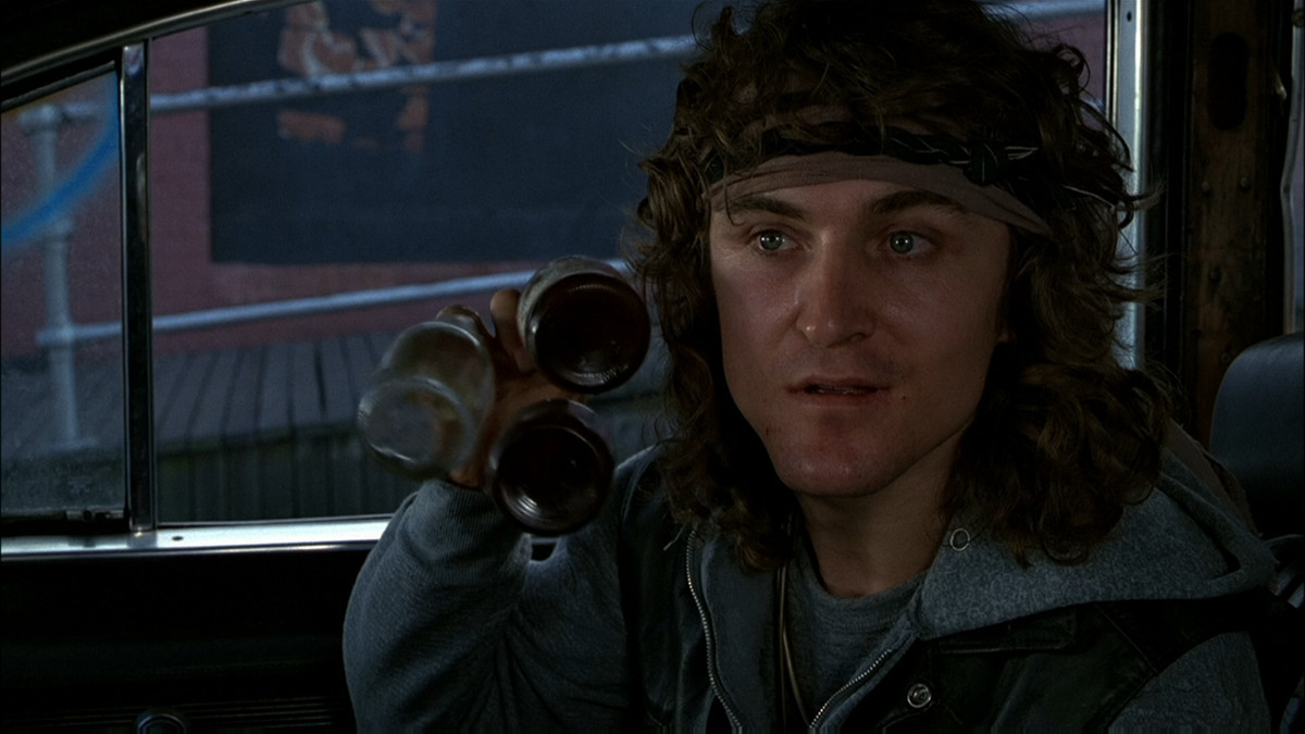 David Patrick Kelly clinks three bottles in the iconic scene from The Warriors.