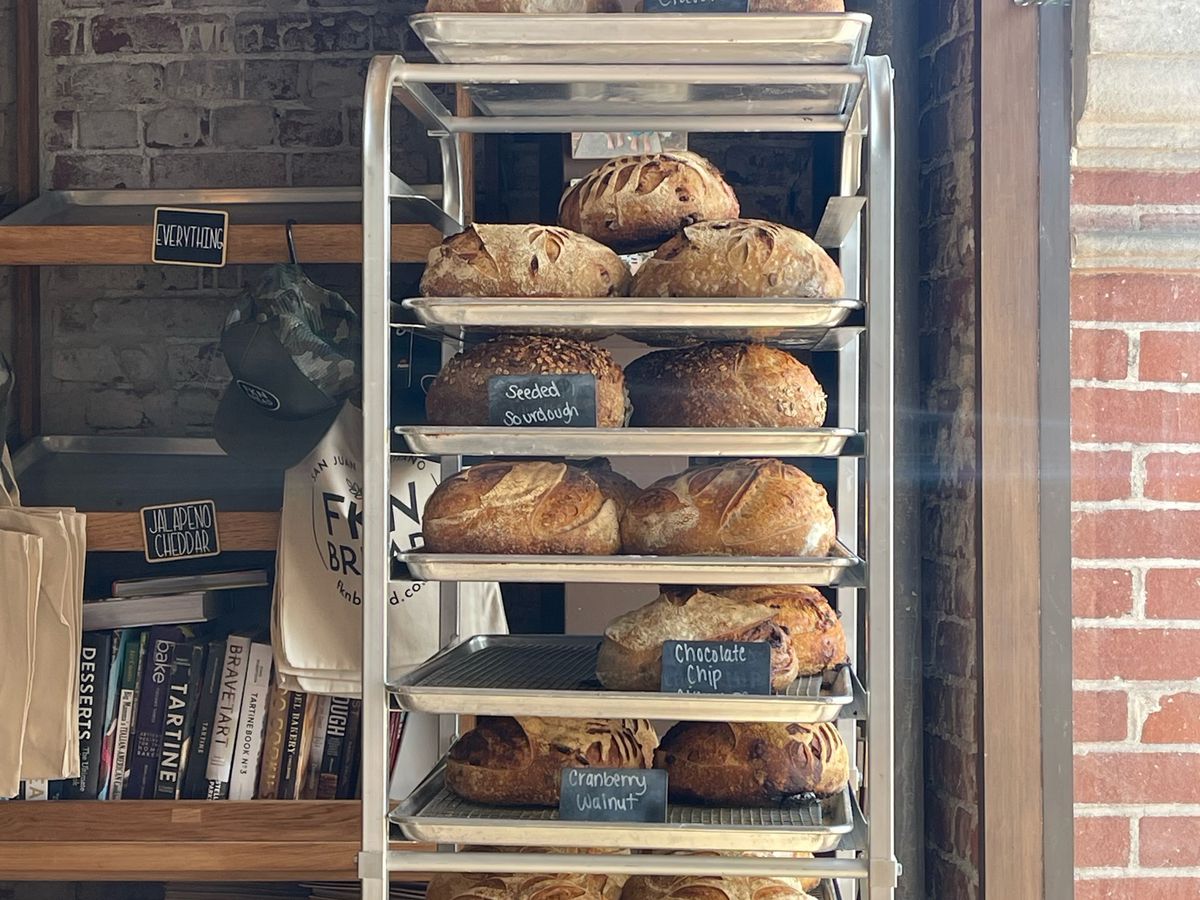 A vertical tray of baked goods inside a sunny brick bakery.