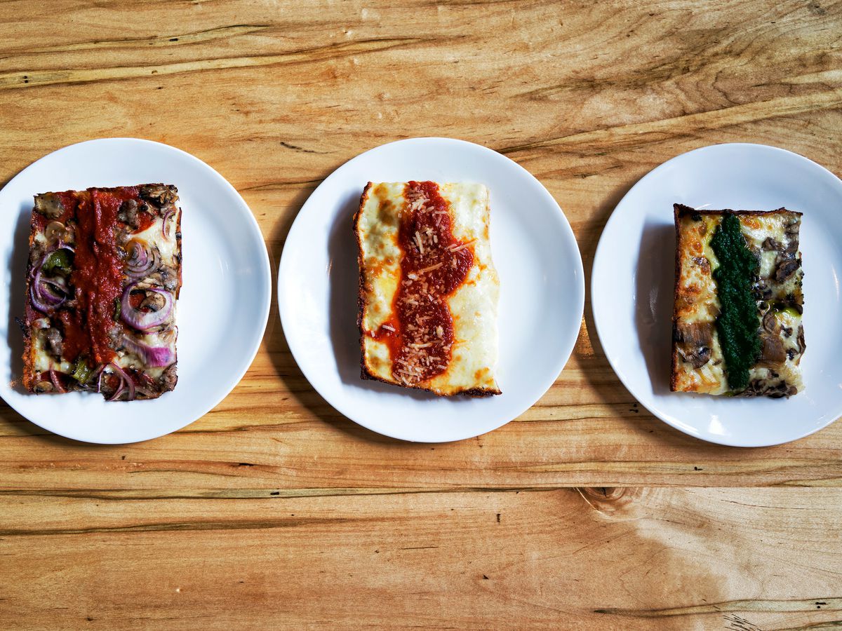 Three slices of pizza on three plates.