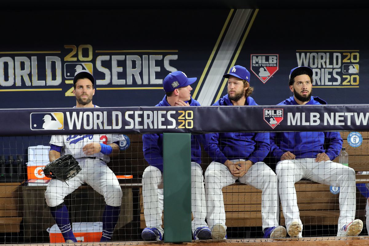 Chris Taylor #3, Walker Buehler #21, Clayton Kershaw #22 and Edwin Rios #43 of the Los Angeles Dodgers are seen in the dugout during Game 2 of the 2020 World Series between the Los Angeles Dodgers and the Tampa Bay Rays at Globe Life Field on Wednesday, October 21, 2020 in Arlington, Texas.