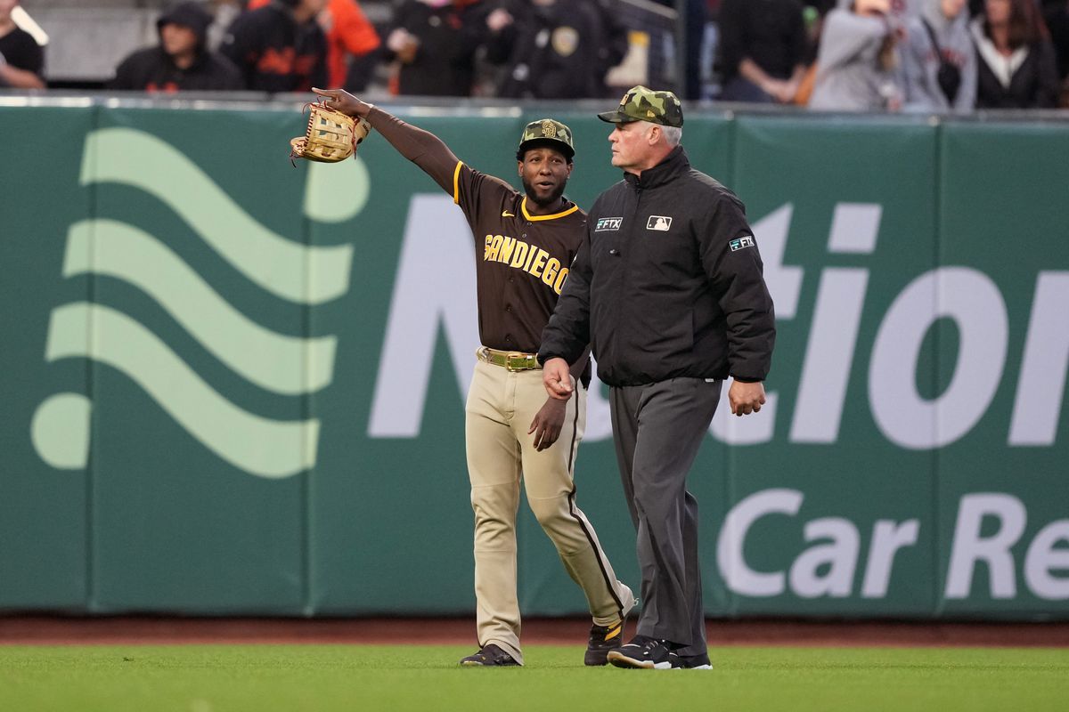 A photo of Jurickson Profar of the San Diego Padres speaking to second base umpire Ted Barrett during Friday night’s game, after having baseballs and a beer bottle thrown at him.