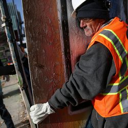 Bill Maynard, who is homeless and living at the Road Home, works with crews from Okland Construction tearing down a wooden fence and replacing it with a metal fence at the Road Home in Salt Lake City on Friday, Dec. 1, 2017.