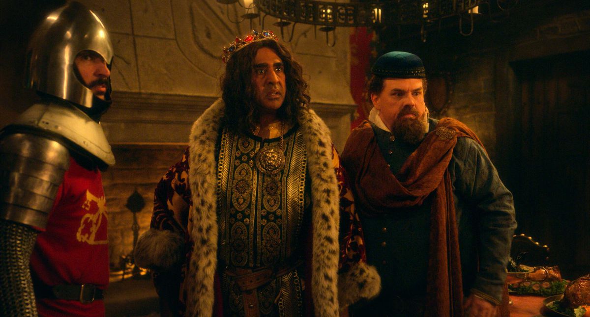 Jay Chandrasekhar, dressed in regal attire as King Guy, and Kevin Heffernan stand next to a knight in Quasi.