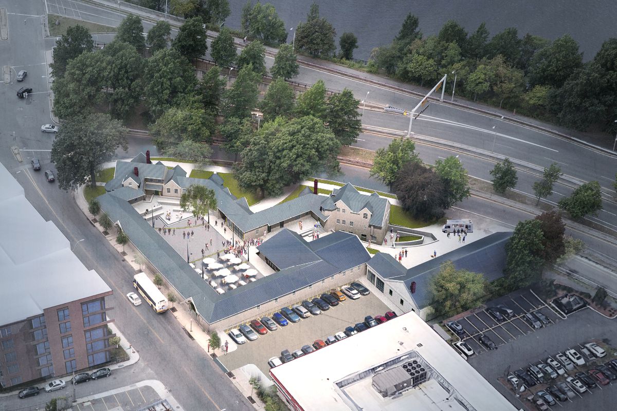 An aerial view of a multibuilding rendering of a brewery and common areas, and it’s all beside a major highway.