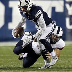 Micah Hannemann of BYU is brought down by a Connecticut defender during NCAA football in Provo, Friday, Oct. 2, 2015.