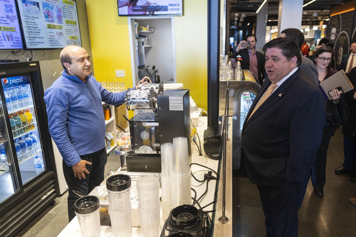 Gov. J.B. Pritzker speaks with Farhad Meghani, co-owner of Snow Dragon Shavery, during a visit to Navy Pier on Monday.