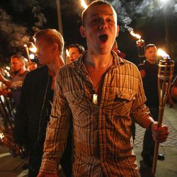 In this photo taken Friday, Aug. 11, 2017, multiple white nationalist groups march with torches through the UVA campus in Charlottesville, Va.   Hundreds of people chanted, threw punches, hurled water bottles and unleashed chemical sprays on each other Saturday after violence erupted at a white nationalist rally in Virginia.  