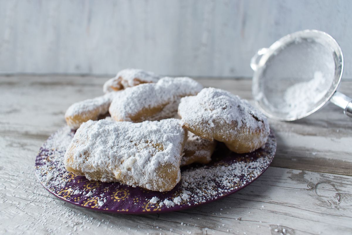 A plate of fluffy beignets covered in powdered sugar.