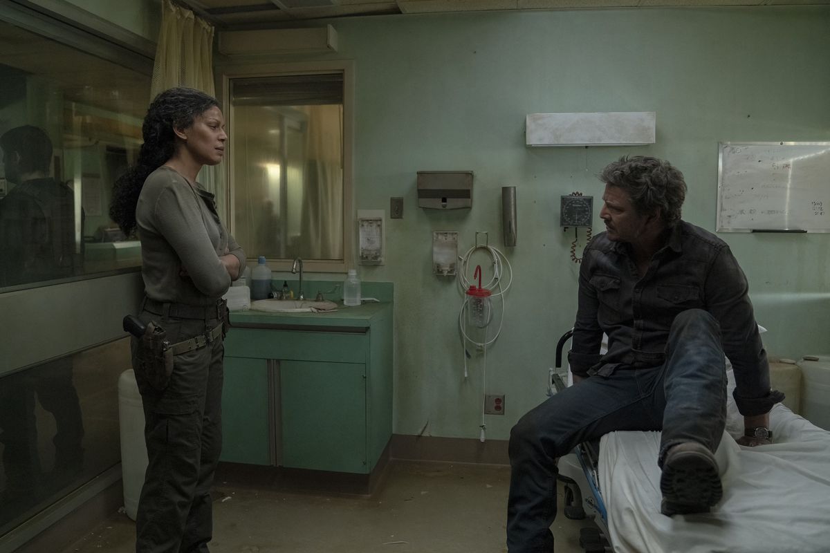 Joel gets up from a hospital bed while Marlene talks to him in HBO’s The Last of Us