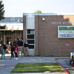 Students, parents, faculty and police stand outside Union Middle School after a shooting involving two juveniles took place on Tuesday, Oct. 25, 2016. The shooting took place outside the school.