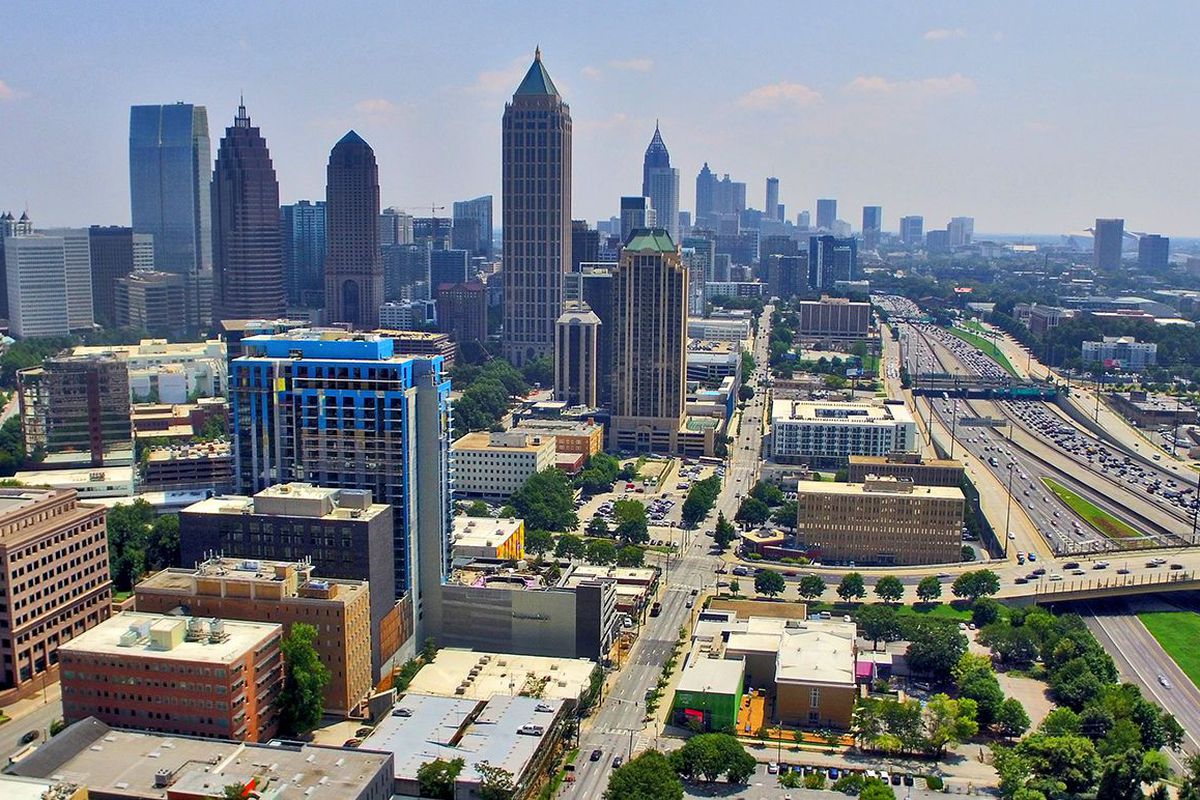 Aerial view of Midtown Atlanta, with a skyline at left and the highway to the right.