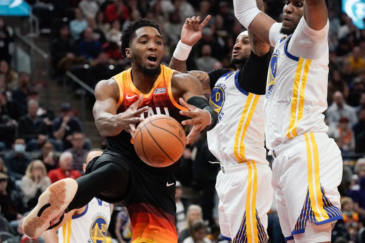 Utah Jazz guard Donovan Mitchell is fouled by Golden State Warriors defenders.