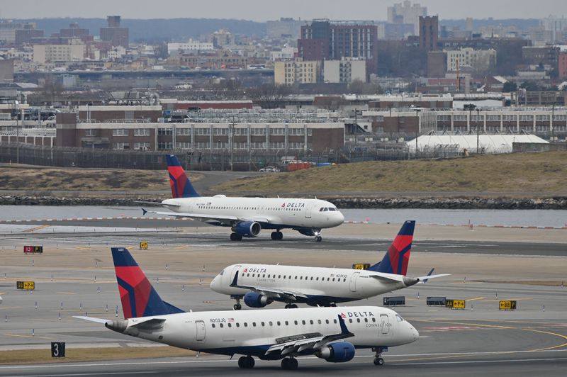 Three Delta Air Lines jets taxi on runways at LaGuardia Airport in New York, on January 11, 2023.